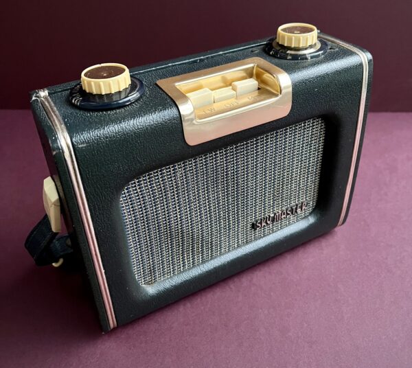Front view of dark blue Ever Ready Sky Master radio showing front speaker grille with its name with wave change pushbuttons set in gold colour surround and rotary volume and tuning controls.