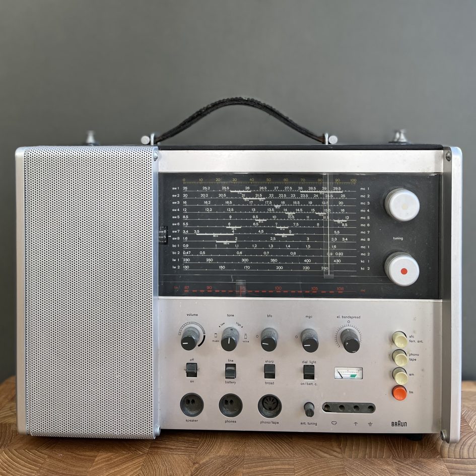 Braun T1000CD front showing the large tuning dial covering 12 wavebands and rows of control knobs for volume, tone, BFO, MGC, bandspread.