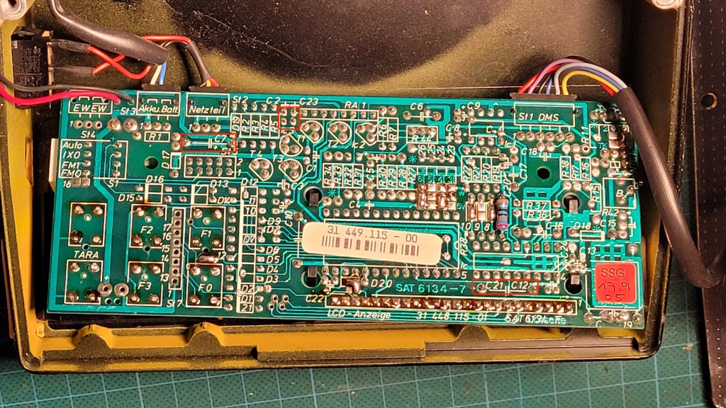 Rectangles indicate the location of the suspect capacitors from the solder side. The component reference numbers are marked in white on the PCB.